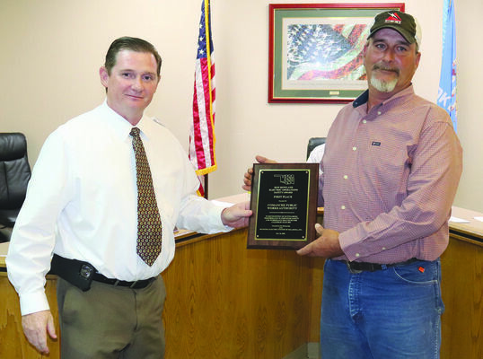 Comanche city manager Chuck Ralls presents the MESO safety award plaque to utilities supervisor Lester Lehew.