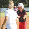 Kenley Lemons gets congratulations from first-base coach Misti Mitchell-Bain after picking up a hit against Anadarko in the season opener on Tuesday. Lemons had two hits in the game.